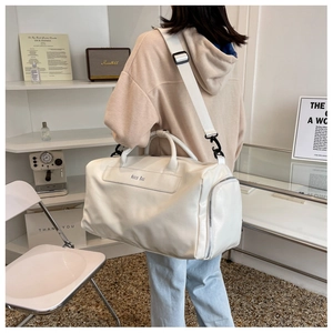 Close-up of the white Noco Bag with lychee texture and adjustable wide shoulder strap