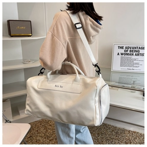 Detail of white leather travel bag with adjustable strap and Noco Bag branding
