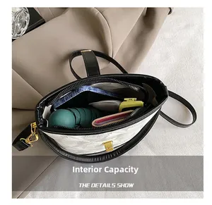 Internal capacity of white half-moon bag showing space for umbrella and wallet