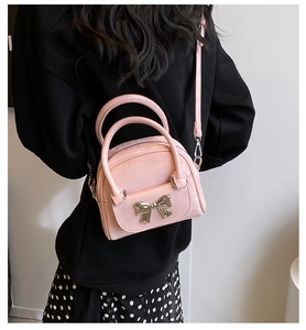 Detailed back view of model wearing pink quilted bucket bag with silver bow detail