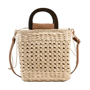 Handwoven straw tote with elegant wooden handles and adjustable brown leather strap