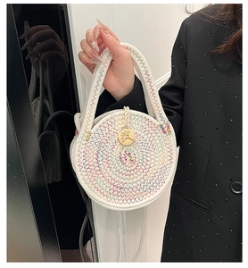 Detail of woven cotton tote bag featuring colorful zigzag stitching and round wooden button