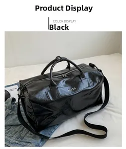 Close-up of black high-gloss travel bag featuring top handles and adjustable shoulder strap