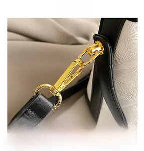 Detail of the high-quality gold hardware and embossed black and white leather on bucket bag
