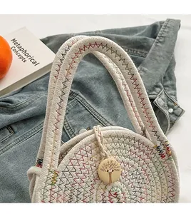 Detail of round woven cotton bag featuring rainbow wave stitching and engraved wood button