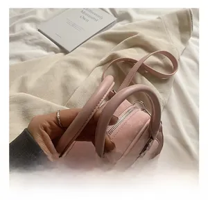 Detailed close-up of pink quilted bucket bag with double handles and metal zipper closure
