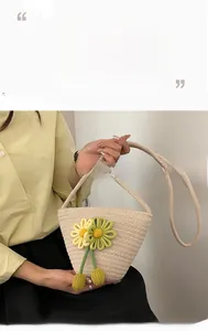 Detail of hand-woven beige straw bucket bag featuring colorful crochet flower charms
