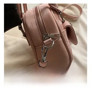 Detailed close-up of premium silver metal hook and pink leather texture on a bucket bag