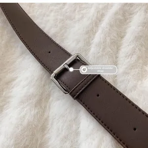 Macro detail of brown pebble leather adjustable strap with polished silver metal buckle