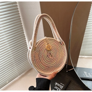 Detailed macro view of woven straw bag with colorful embroidery and wood button