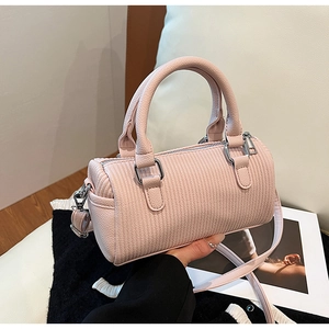 Detailed close-up of pink barrel bag with vertical pleated texture and silver hardware