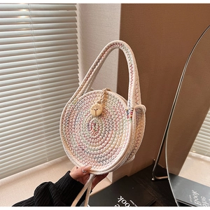 Close-up of a woven straw mini bag featuring colorful stitching and a round wooden buckle