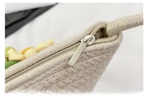 Close-up of woven straw bag fabric showing high-quality silver zipper and texture