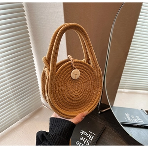 Close-up of woven straw mini round bag with coconut tree pattern button and dual handles