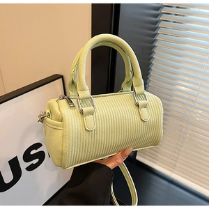 Detail of light green cylinder handbag with pebble leather texture and silver hardware