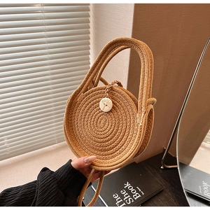 Close-up of circular woven straw mini bag with wooden tree-pattern button closure