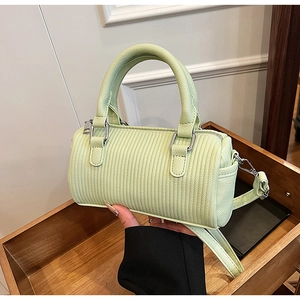 Detail view of the pale green barrel bag showing vertical ribbed texture and silver hardware