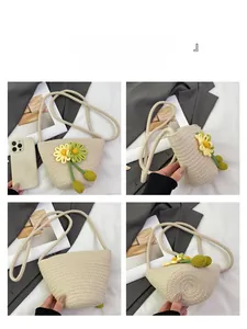 Close-up of beige woven bucket bag with 3D floral accents and slender shoulder strap