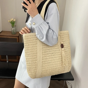 Large beige woven straw tote bag with tassel and wood bead for summer beach holidays