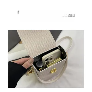 Internal capacity of beige woven crossbody phone bag showing space for smartphone and lipstick