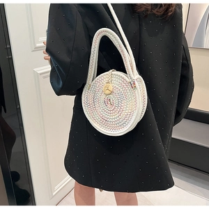 Detail of a round woven handbag with colorful spiral embroidery and central wooden button