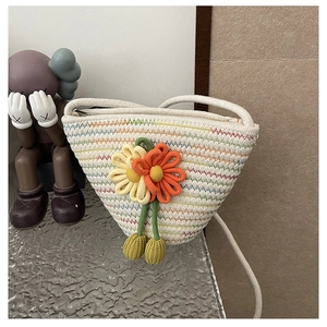 Close-up of handmade woven straw bag with colorful wavy stitching and 3D floral accents