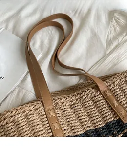 Detail of hand-woven tote bag showing texture and brown leather strap with stitching