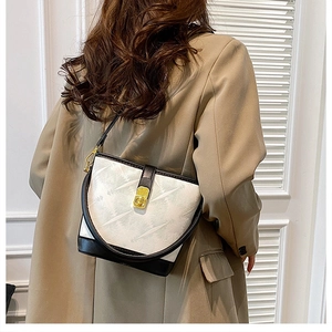 Close-up of black and white leather bucket bag with textured finish and gold buckle lock