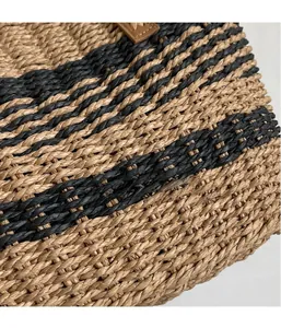 Close-up of the textured hand-woven straw tote with black and brown vertical stripes