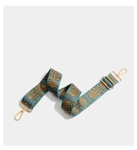 Close-up of bohemian embroidered strap with peacock pattern and gold metal hooks