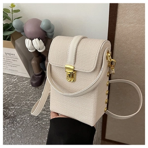 Close-up of cream woven texture phone bag with gold metal clasp and side rivets detail