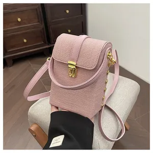 Detailed macro view of pink crossbody phone bag with textured leather and gold clasp hardware