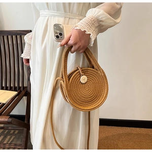 Detail shot of mini round straw bag showing spiral woven texture and wooden button