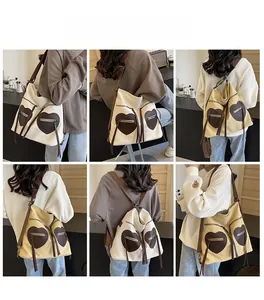 Detail view of canvas tote with heart-shaped pockets and adjustable straps shown on model