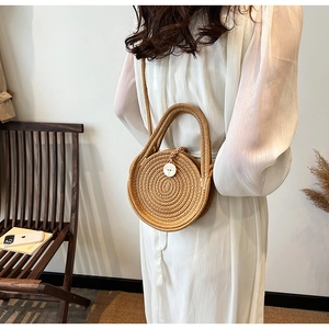 Detail of round straw bag showing the woven texture and tree-engraved button closure