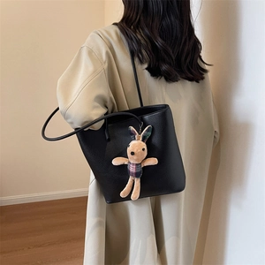 Large black leather tote bag with rabbit charm shown on model for casual commuting