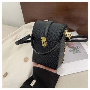 Detailed view of a black textured vertical mini bag with gold hardware and rivets