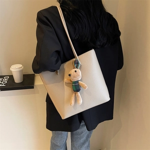 Minimalist off-white pebbled leather tote bag with a cute plaid plush bunny charm