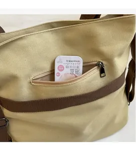 Close-up of front zipper pocket on canvas tote bag showing storage space for small items