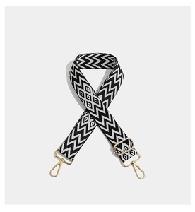 Detailed view of bohemian embroidered strap with geometric patterns and gold metal hooks