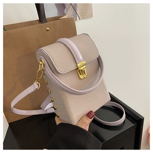 Close-up of light purple crossbody phone bag featuring gold studs and push-lock closure