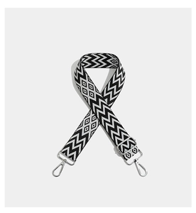 Detail of adjustable woven bag strap featuring black and white geometric jacquard patterns