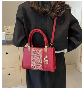 Detail of red wedding handbag with golden floral embroidery and double happiness charm