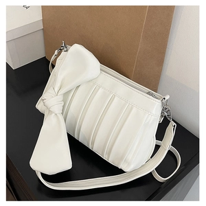 Dettaglio della borsa in pelle bianca a pieghe con fiocco grande e cerniera in metallo
