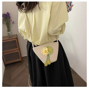 Detail of woven cotton bucket bag featuring yellow daisy flowers and shoulder strap