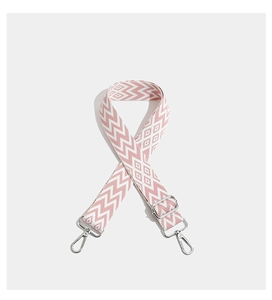 Close-up of pink and white geometric embroidered wide strap with silver metal buckles