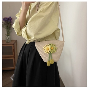 Detail of woven straw bucket bag with large yellow daisy flowers for beach vacation style