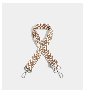 Detail of adjustable embroidered bag strap with brown geometric wave pattern and silver hooks