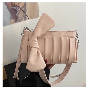 Dettaglio della borsa a tracolla rosa chiaro con design a pieghe e grande fiocco decorativo