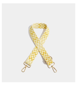 Close-up of bohemian yellow geometric embroidery on wide bag strap with gold metal hooks